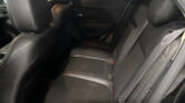 Back seat of a car with black leather seats, visible headrests and center armrest.