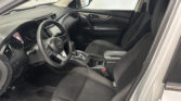Inside view of a car cabin featuring the driver’s seat and front passenger seat, steering wheel, center console, and touchscreen display.