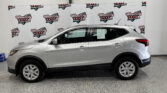 Side view of a silver SUV parked indoors, with Wheel City Auto Finance Centers banners in the background.
