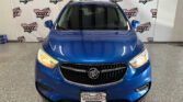 Front view of a blue Buick SUV in a showroom with a Wheel City Auto Finance Centers backdrop and license-plate frame.