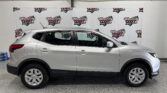 Side view of a silver SUV inside a showroom with Wheel City Auto Finance Centers banners in the background.