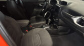 Front interior of a car with black fabric seats, steering wheel, center console, and dashboard viewed from the passenger side door open edge.
