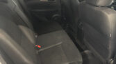 View of the car's back seats and rear door panel in a dark fabric interior.