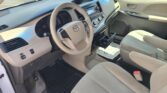 Interior of a beige Toyota car showing steering wheel, dashboard, and front seats from the driver's side