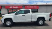 White pickup truck parked in front of a red storefront with signs reading All Credit and Wheel City Auto.Since 1993 is also visible on the sign?
