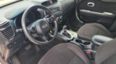 Interior of a Kia car focusing on the dashboard, steering wheel, and center console with an automatic shifter, in a parked position.