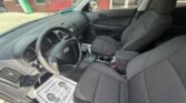 Interior of a dark-gray Hyundai sedan showing the front seats, steering wheel, dashboard, and center console