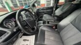 Front interior of a dark pickup truck: driver and passenger seats, steering wheel, center console, and floor mat with a thank-you note visible on the driver's side.