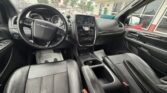 Black SUV interior with steering wheel, center touchscreen, climate controls, and front leather seats.