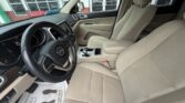 Interior of a beige SUV: steering wheel, dashboard, and front seats visible from the driver's side, center console with gear shifter in view