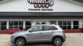 Silver SUV parked in front of Wheel City Auto Finance Centers storefront.