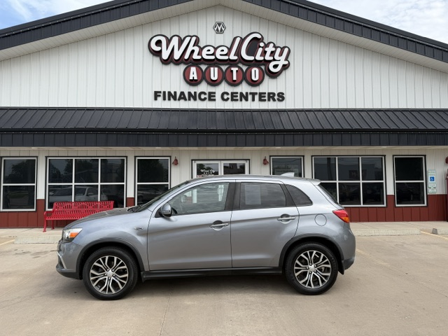 Silver SUV parked in front of Wheel City Auto Finance Centers storefront.