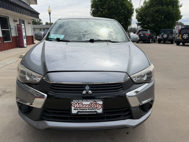 Front view of a silver Mitsubishi SUV parked in a dealership lot, with a Wheel City Auto Finance Centers license plate frame on the front bumper.