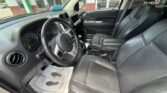 Front interior of a black SUV with driver and passenger seats, steering wheel, and dashboard visible, leather seats and center console with cup holders.