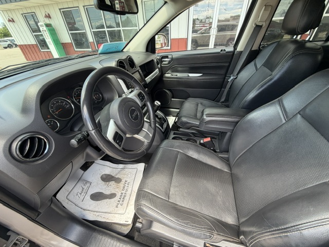 Front interior of a black SUV with driver and passenger seats, steering wheel, and dashboard visible, leather seats and center console with cup holders.