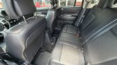 Black leather rear seating area with two captain-style front seats and a bench back seat, cup holders in the center, and roofline vents visible through windows