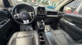 Front interior of a black leather Jeep with steering wheel, dashboard, and center console visible.