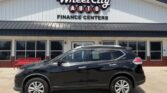 Black SUV parked in front of the Wheel City Auto storefront with a white building and bold dealership sign above the entrance.