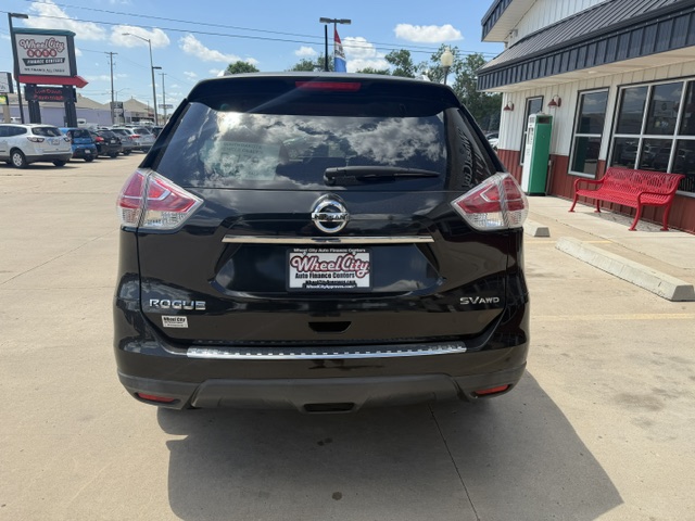 Rear view of a black Nissan Rogue SV AWD SUV in a parking lot, dealership plate reading Wheel City Auto.