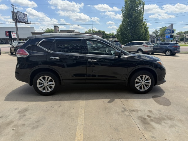 Side view of a black mid-size SUV parked in a sunny parking lot, with other cars and trees in the background.