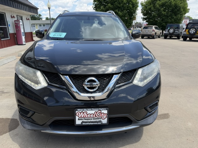 Front view of a dark blue Nissan SUV at a dealership, with a WheelCity Auto Finance Centers plate frame and a windshield sticker visible.