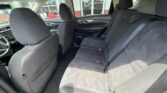 Interior of a car showing a gray fabric three-seat rear bench with headrests and seat belts, front seats visible.