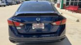 Rear view of a blue Nissan Altima parked in a dealership lot, with a Wheel City Auto Finance Centers license plate frame visible.
