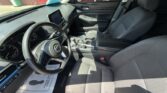 Front interior of a modern car, showing the steering wheel, dashboard, and two front seats from the passenger side.