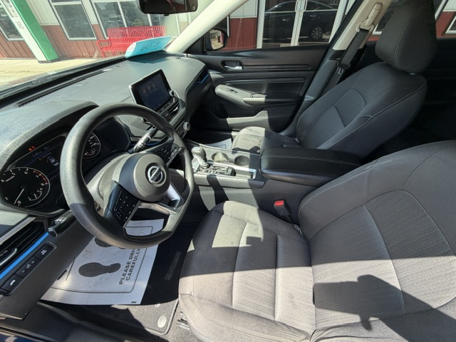 Front interior of a modern car, showing the steering wheel, dashboard, and two front seats from the passenger side.