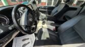 Interior view of a pickup truck cabin with black leather seats, steering wheel, and center console, front passenger seat visible and dashboard in view.