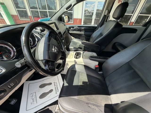 Interior view of a pickup truck cabin with black leather seats, steering wheel, and center console, front passenger seat visible and dashboard in view.