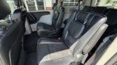Interior of a black-leather second-row seating area in a vehicle, showing two captain's chairs and aisle to the back doors