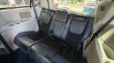 Rear row of black leather seats in an SUV, three seats with headrests and visible seat belts.