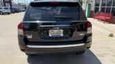 Rear view of a black Jeep SUV in a dealership lot, showing 4x4 badge and dealer plate frame reading Wheel City Auto Finance Centers.