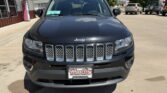Front view of a black Jeep SUV parked in a dealership lot, featuring the seven-slot grille and chrome accents.