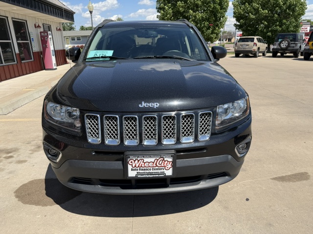 Front view of a black Jeep SUV parked in a dealership lot, featuring the seven-slot grille and chrome accents.