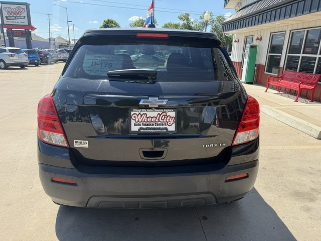 Rear view of a black Chevrolet Trax LT SUV at a car dealership, with Wheel City Auto Finance Centers license plate frame.