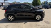 Side view of a black four-door SUV parked in a sunny dealership lot.