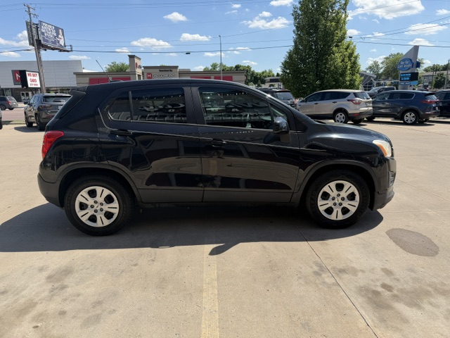Side view of a black four-door SUV parked in a sunny dealership lot.