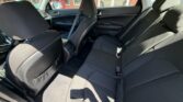 Back seat of a black cloth sedan with three-seat belt setup and door panels visible on the sides.