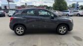 Side view of a dark gray SUV parked in a lot with other cars nearby, under a partly cloudy sky.
