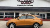 Orange SUV parked in front of Wheel City Auto Finance Centers storefront.