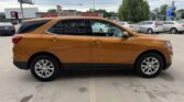 Orange-brown Chevrolet Equinox SUV parked in a dealership lot, side view with tinted windows and silver wheels.