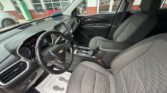 Interior view of a Chevrolet car showing the steering wheel, dashboard, and gray cloth front seats