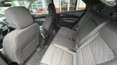 Rear interior of a car with gray fabric seats, two outer rear seats and a center seat, front seats and door panels visible