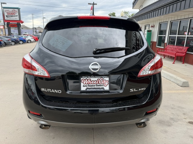 Rear view of a black Nissan Murano SL AWD parked at a dealership, showing taillights, rear wiper, and a Wheel City Auto Finance Centers plate.