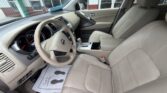 Front interior of a beige leather SUV, showing the steering wheel, dashboard, and center console from the driver's seat view.
