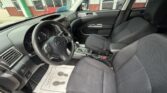 Interior of a dark fabric-seat car, with the steering wheel and center console visible from the driver’s side.