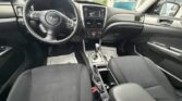 Subaru car interior with black cloth seats, steering wheel, center console gear lever, and dashboard touchscreen display.