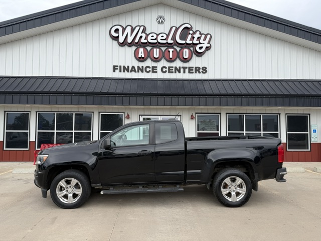 Black pickup truck parked in front of Wheel City Auto Finance Centers storefront sign.